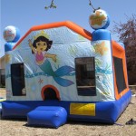 Dora the Exploerer Mermaid bounce house jump house rental on grass in sunlight