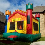 Medieval Air Castle bounce house jump house in front of a house on grass