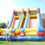 colorful primary colored double two slide combination inflatable rental on grass