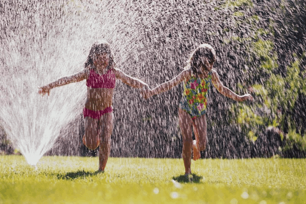 kids running through sprinkler