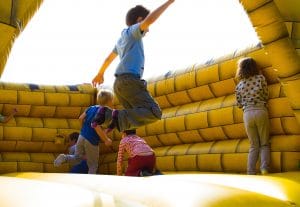 four-kids-playing-in-yellow-bounce-house 