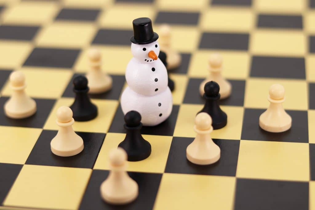 snowman surrounded by chess pieces