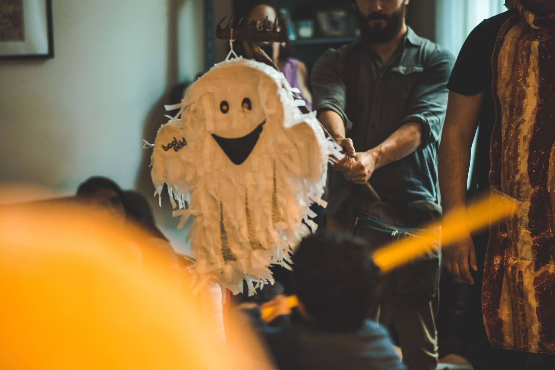 family inside home hitting halloween ghost pinata