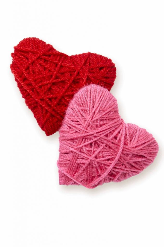 two yarn wrapped hearts one in red yarn and one in pink yarn