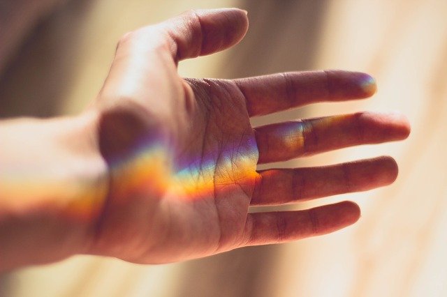 rainbow light shining on a hand