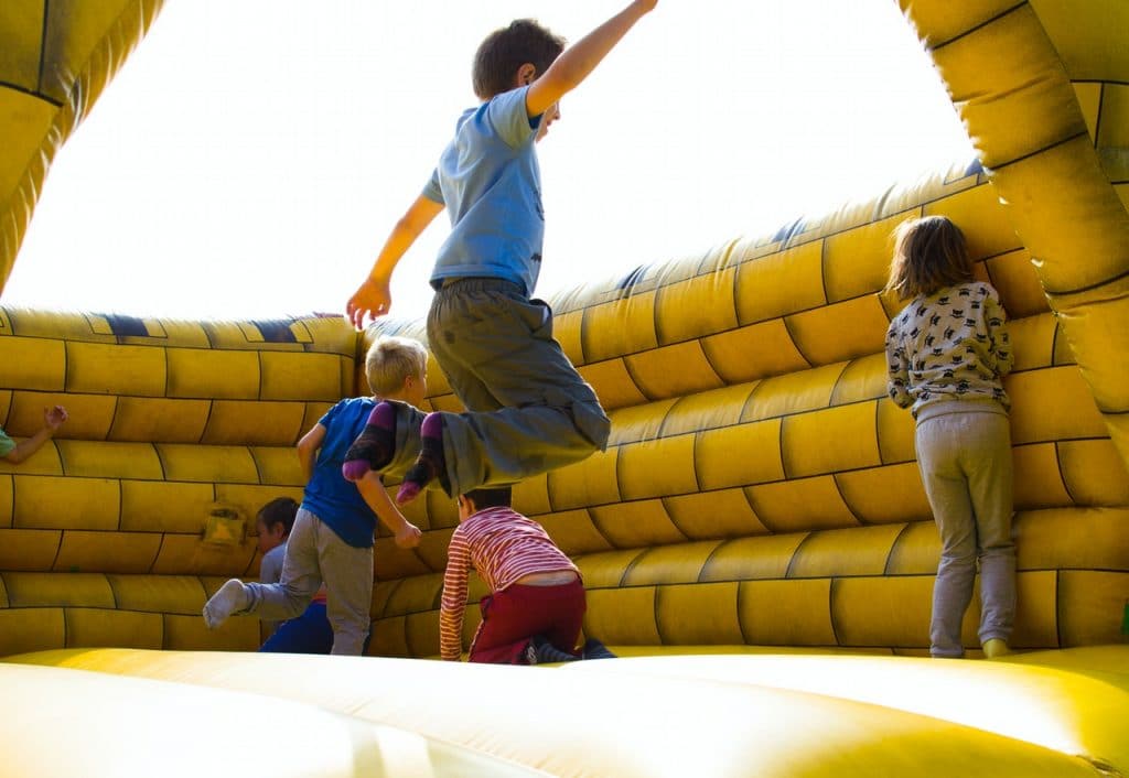 kids on a bounce house jumping outside