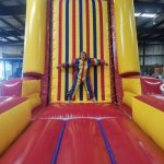 Velcro wall inflatable rental with woman stuck on the wall