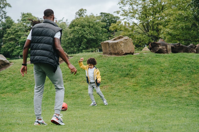 father and kid outside playing ball