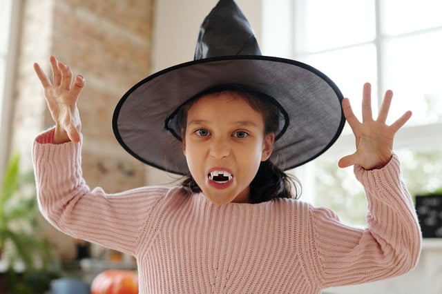 little girl dressed up for Halloween as a witch