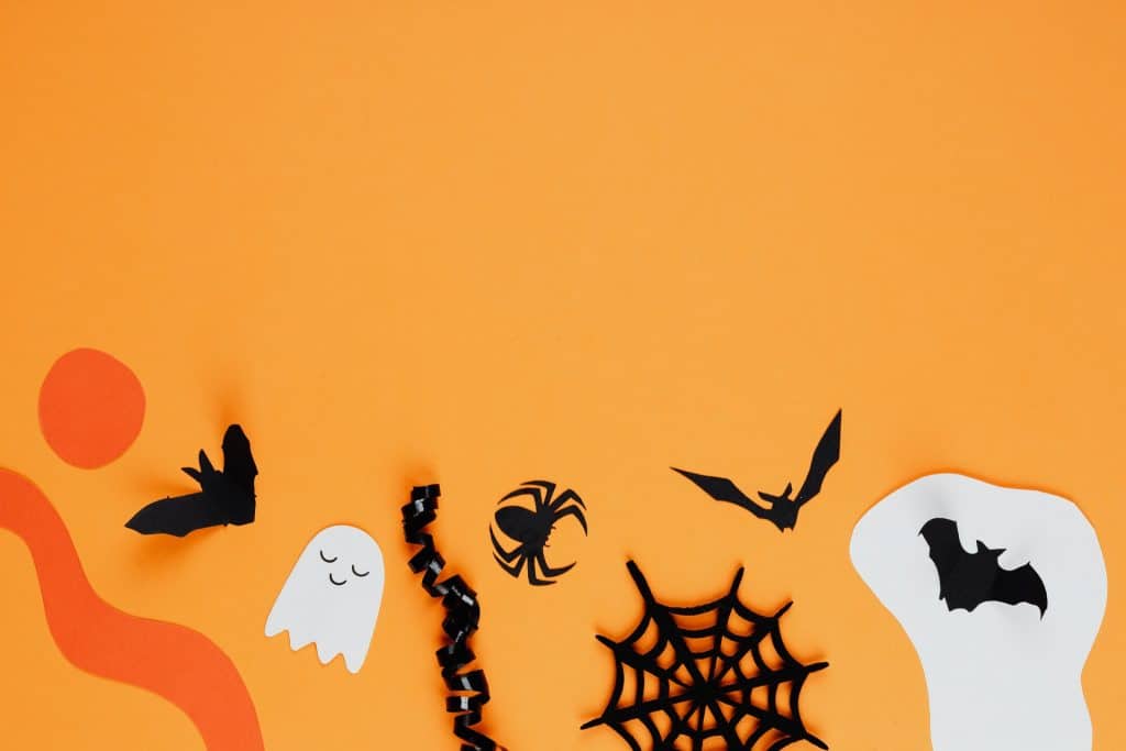 Halloween paper cutouts on an orange background