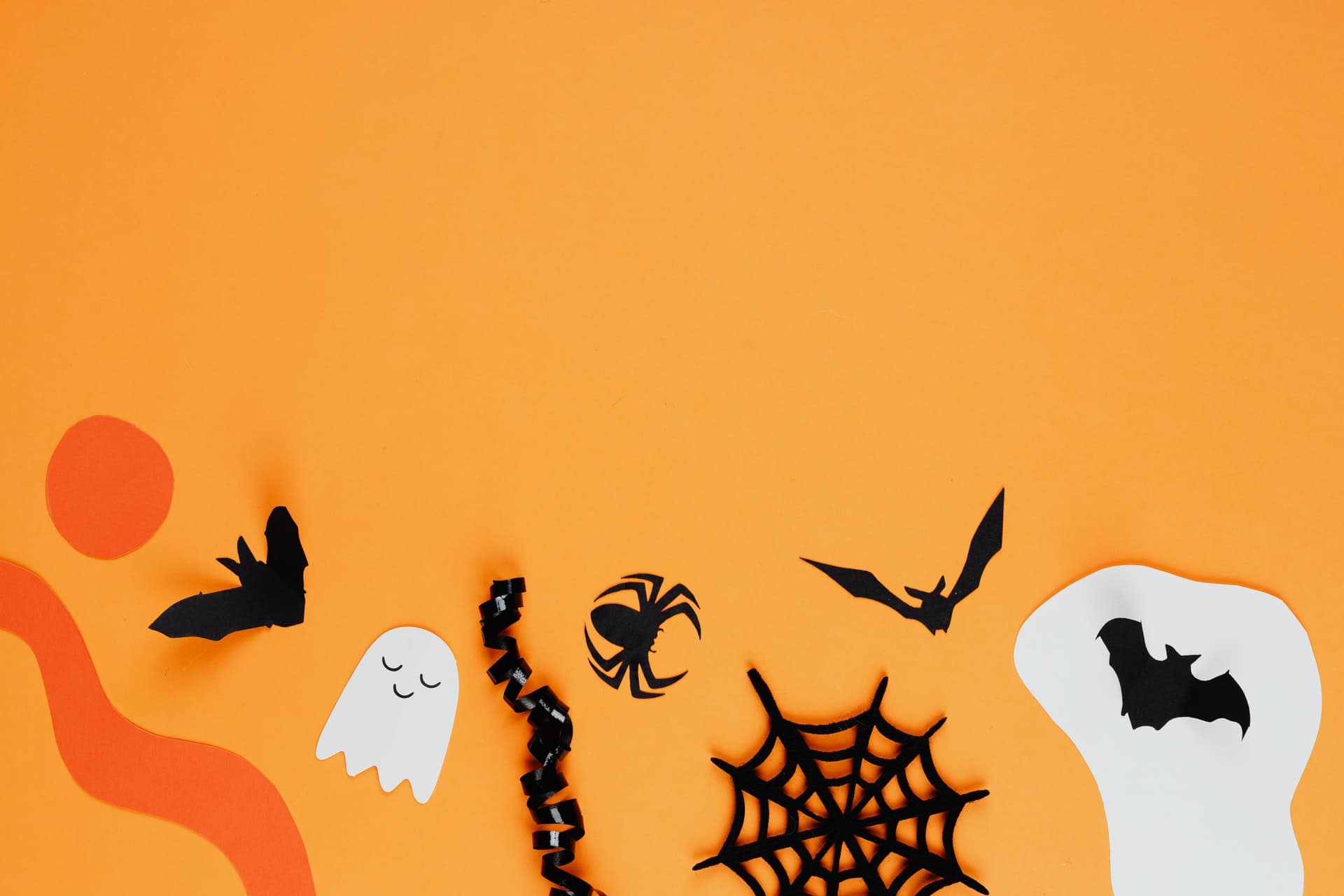 Halloween paper cutouts on an orange background