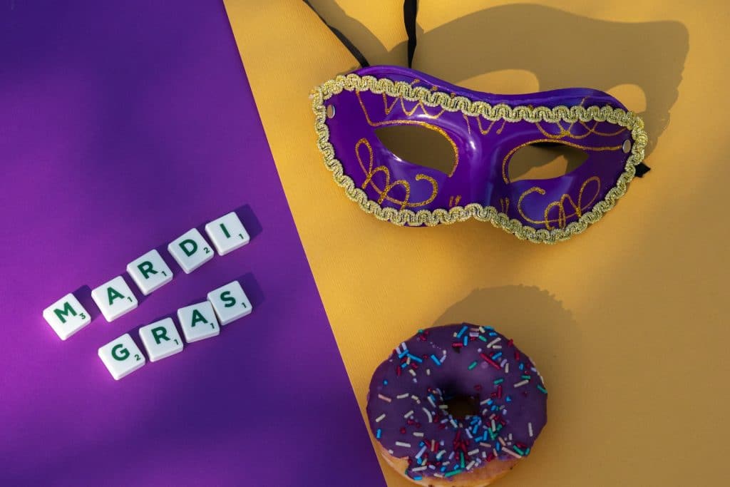 purple and yellow mardi gras with mask and purple donut